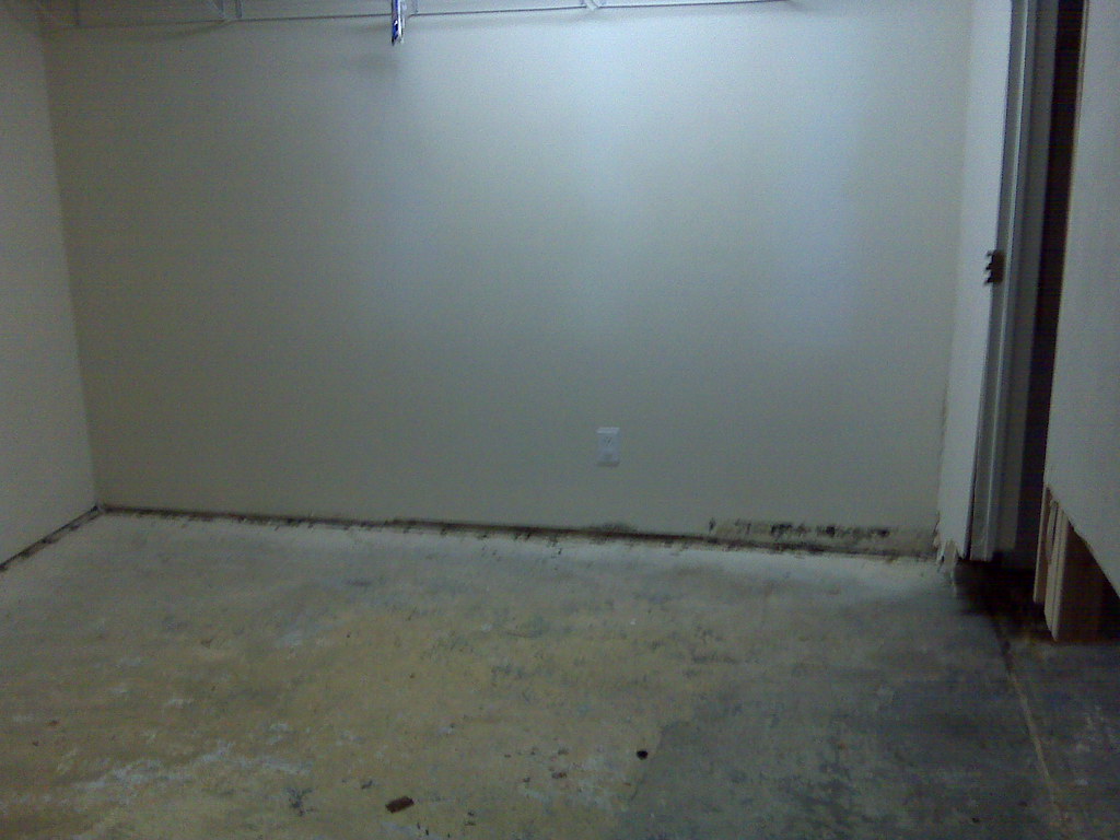 Traces d’humidité et finition retirée au pied d’un mur intérieur