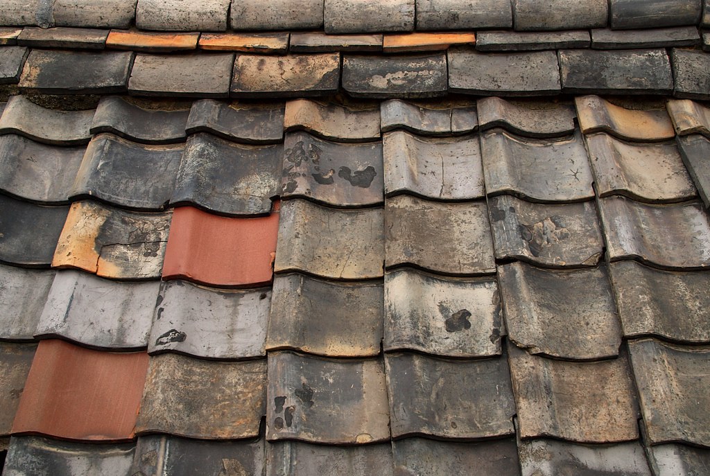 Tuiles anciennes présentant plusieurs reprises avant rénovation