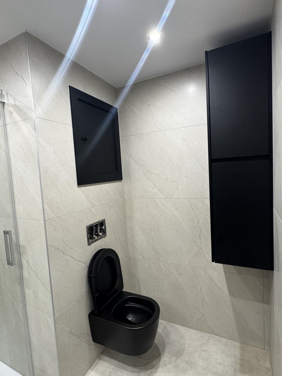Salle de bain en marbre clair avec sanitaires noirs